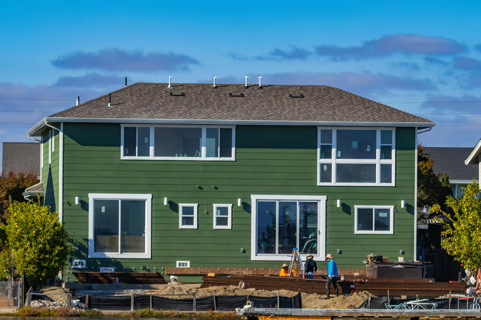 Home with new siding and workers on site